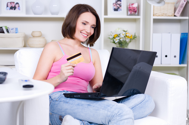 Beauty woman holding credit card and using laptop for online shopping - indoors